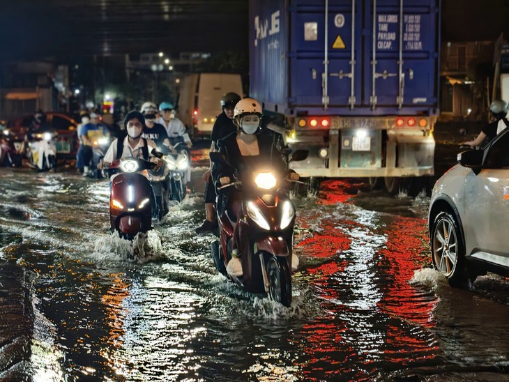 Ngã tư Nguyễn Văn Quỳ - Đào Trí ngập do triều cường, người dân dò dẫm né ổ gà, tránh xe container - Ảnh 2.