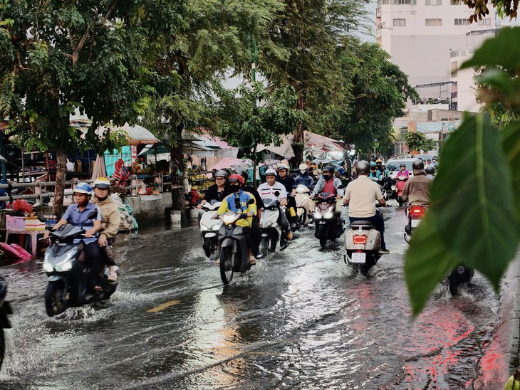 Ngã tư Nguyễn Văn Quỳ - Đào Trí ngập do triều cường, người dân dò dẫm né ổ gà, tránh xe container - Ảnh 4.