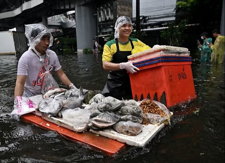 Bangkok ngập lụt, người dân lội nước đi chợ - Ảnh 1.