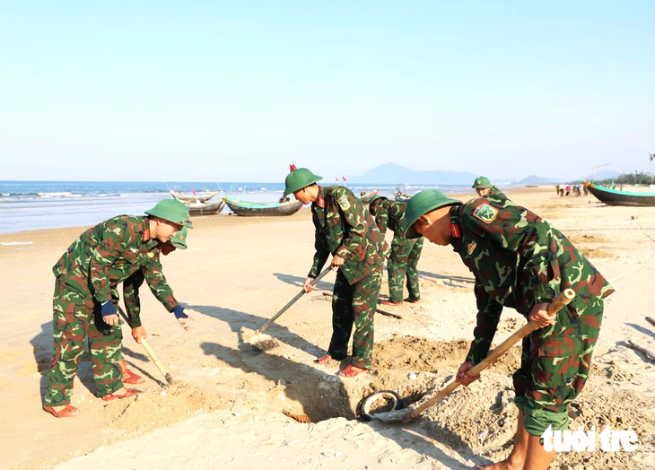 Bộ đội tham gia thu gom hàng tấn vỏ ngao tím trôi dạt vào bờ biển - Ảnh 3.