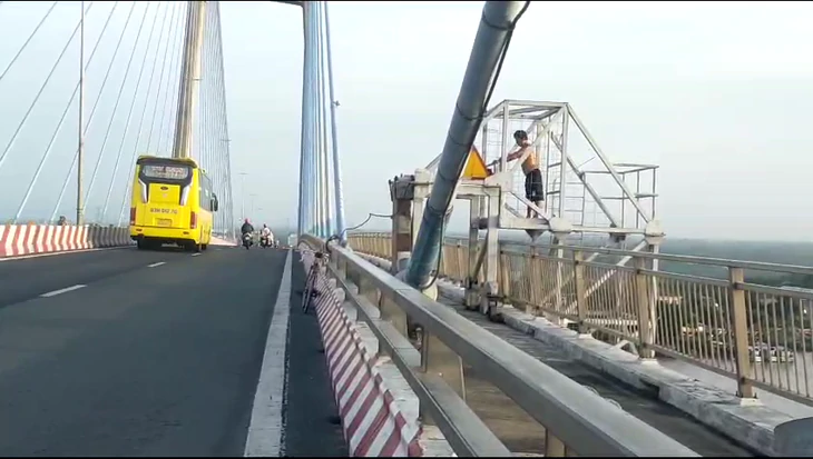 Người đàn ông leo lên lan can cầu Mỹ Thuận 1 tập thể dục, tiềm ẩn nguy hiểm - Ảnh 2.