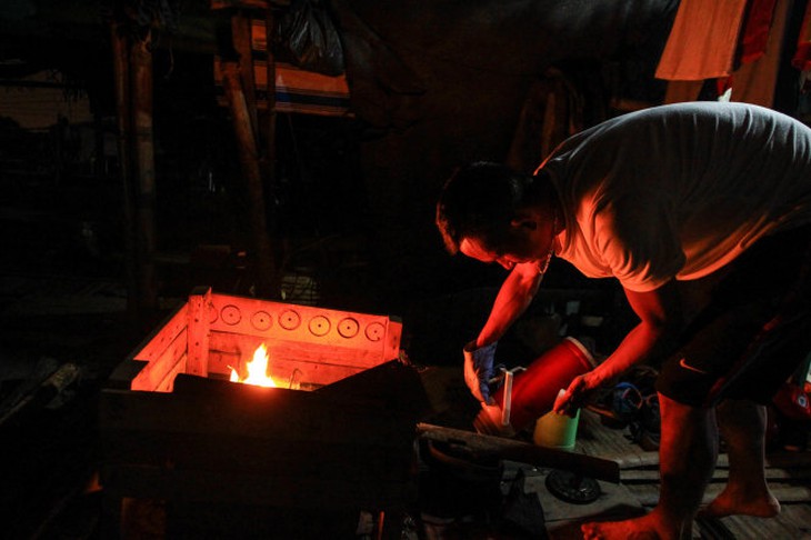 7 giờ tối, anh Lộc bắt đầu nhóm lửa trên thuyền để chuẩn bị cho bữa cơm tối