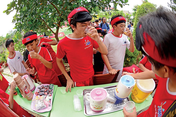 Cầu thủ hai đội tranh thủ giải lao uống nước để tiếp tục thi đấu - Ảnh: Quang Định