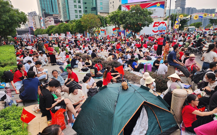 Before sunset, people lay tarps, pitch tents to claim spots for April 30 parade in Ho Chi Minh City