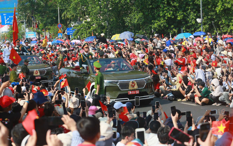 Troops march through downtown streets of Ho Chi Minh City, cheered on by residents