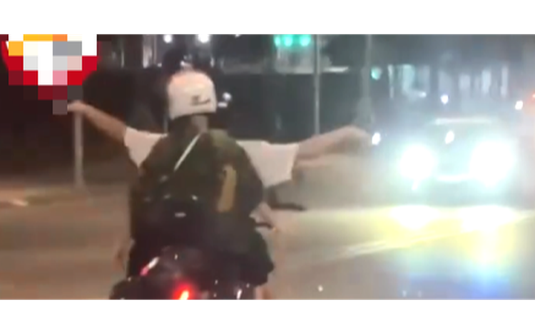 Foreigner has motorcycle confiscated for riding hands-free in ‘flying bird’ pose in Da Nang