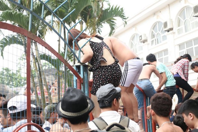 People scramble over fence for free baths in Hanoi (video)