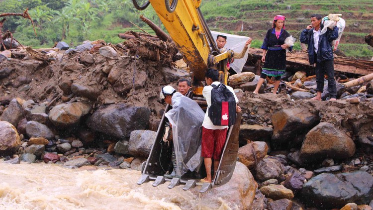 In Vietnam, excavator bucket ferries stranded villagers over swollen stream