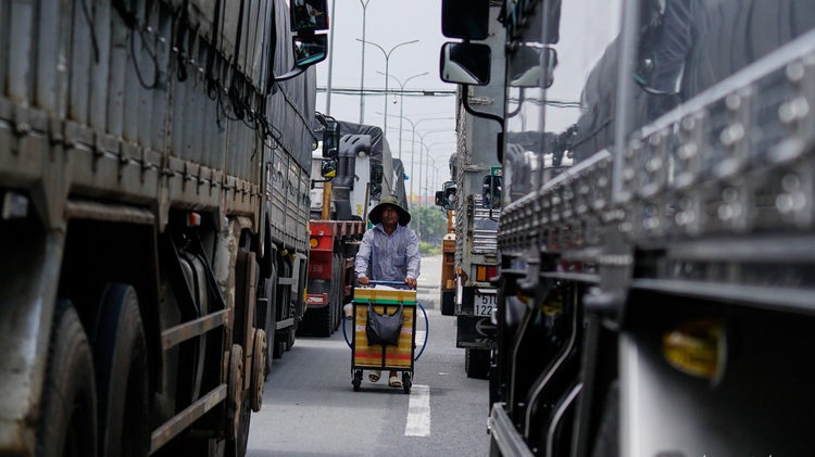 Saigon vendors risk life and limb hawking goods in middle of national highway