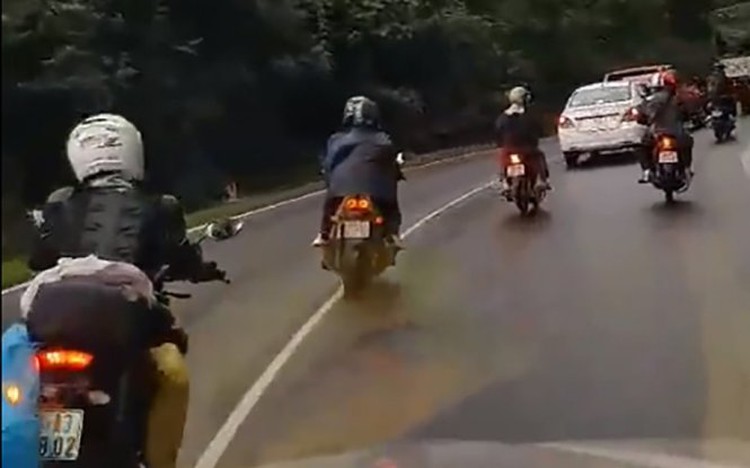 Bikers roar with wailing sirens, noisy mufflers on Vietnamese highway