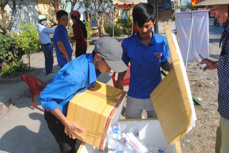 Man hands free water, tissues to people heading home for Tet reunion in Vietnam’s Mekong Delta
