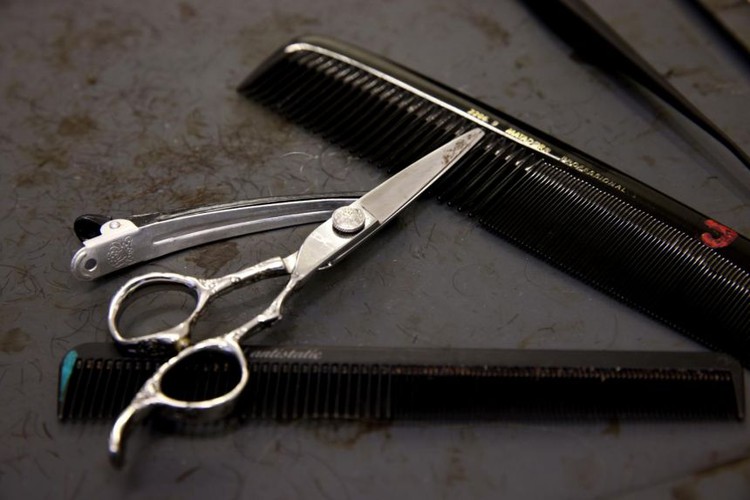 After losing arm, Vietnamese hairdresser styles new ways to cut clients' locks