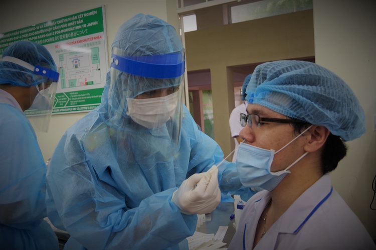 What should I do if I have COVID-19 symptoms in Vietnam?