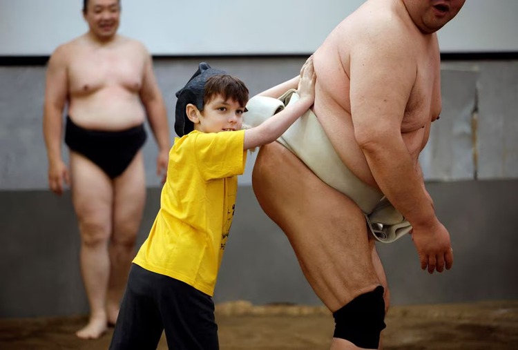 Sumo retirees play for laughs from tourists flooding back to Japan