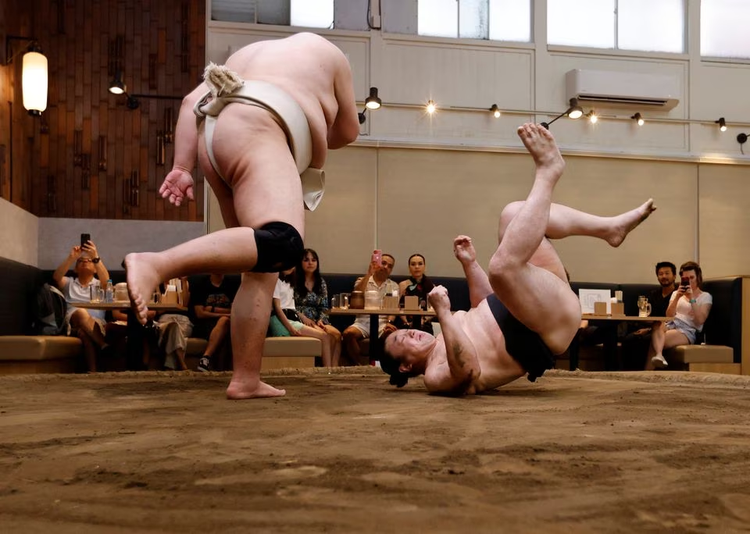 Sumo retirees play for laughs from tourists flooding back to Japan