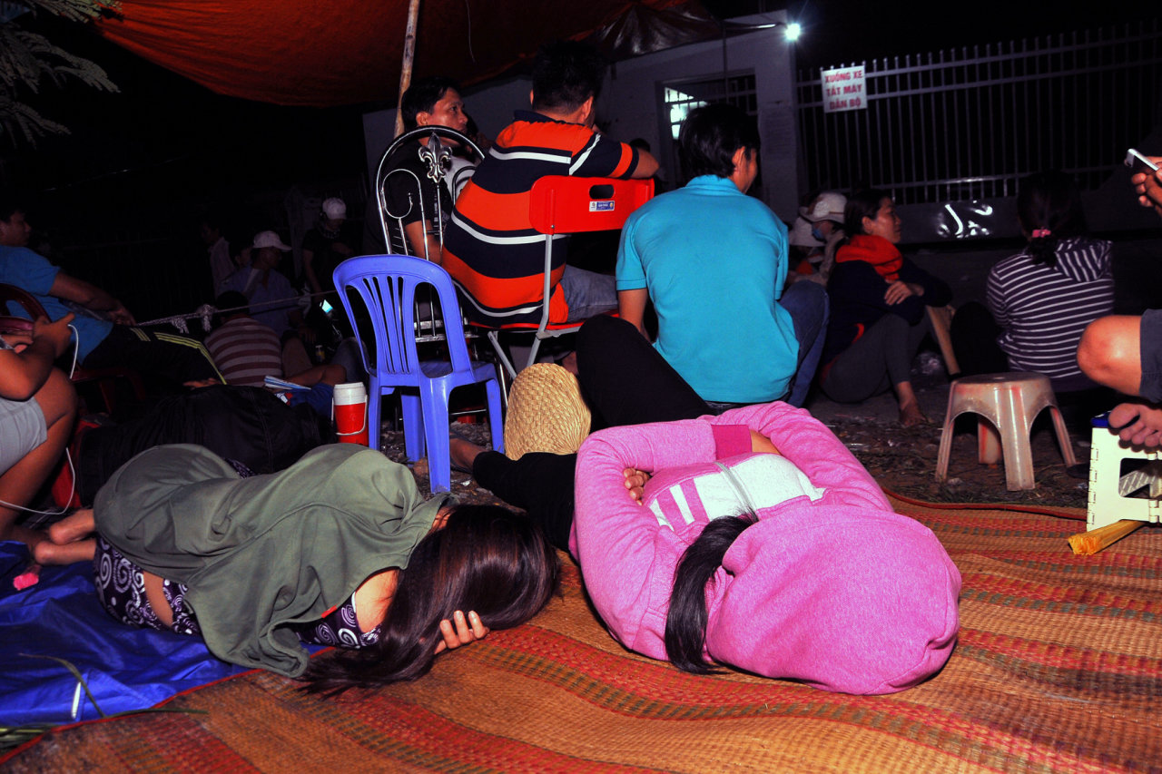Parents take a nap on mats that they had brought with them. Photo: Tuoi Tre