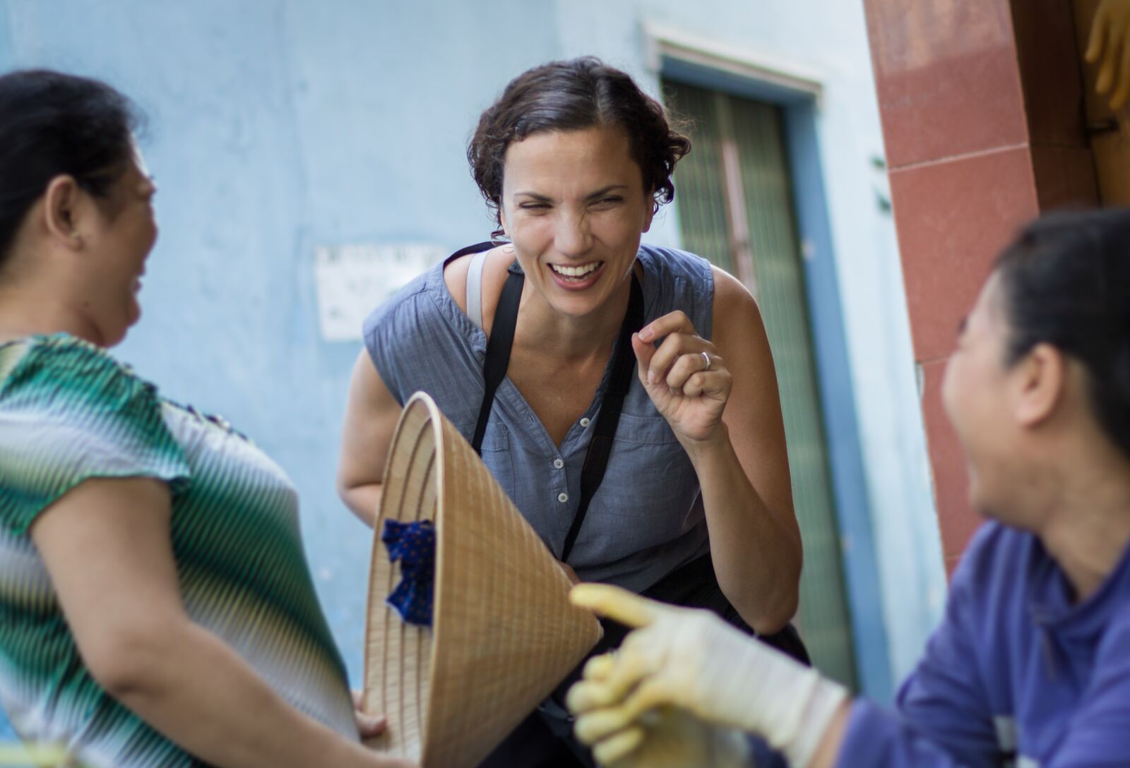Tanya Olander laughing with two local vendors in a photo taken by photographer Maria Graven while the two were shooting in District 3 – Photo provided by Tanya Olander