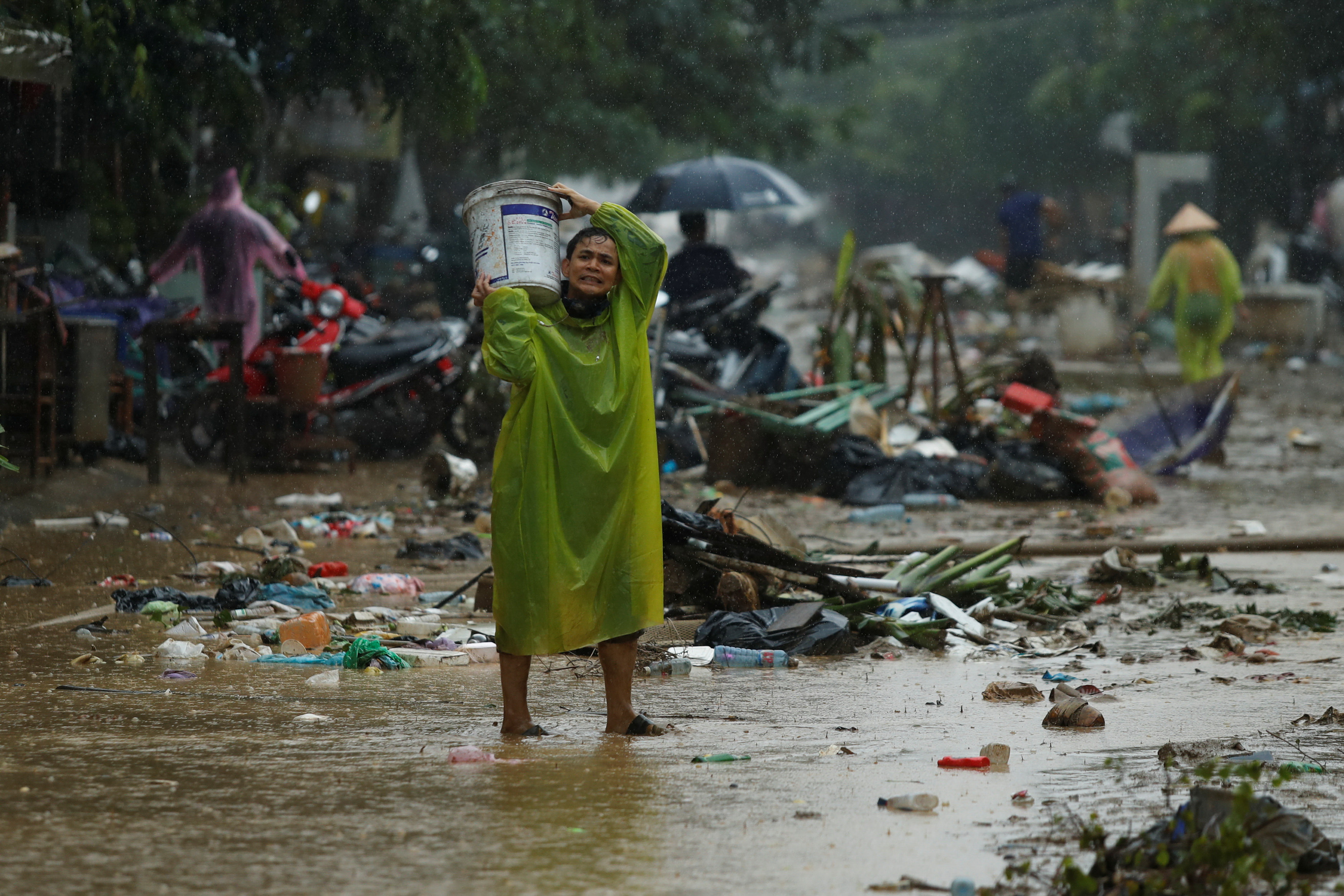 People clean mud from a street caused by flooding by Typhoon Damrey, in the ancient UNESCO heritage town of Hoi An, Vietnam November 8, 2017. Photo: Reuters
