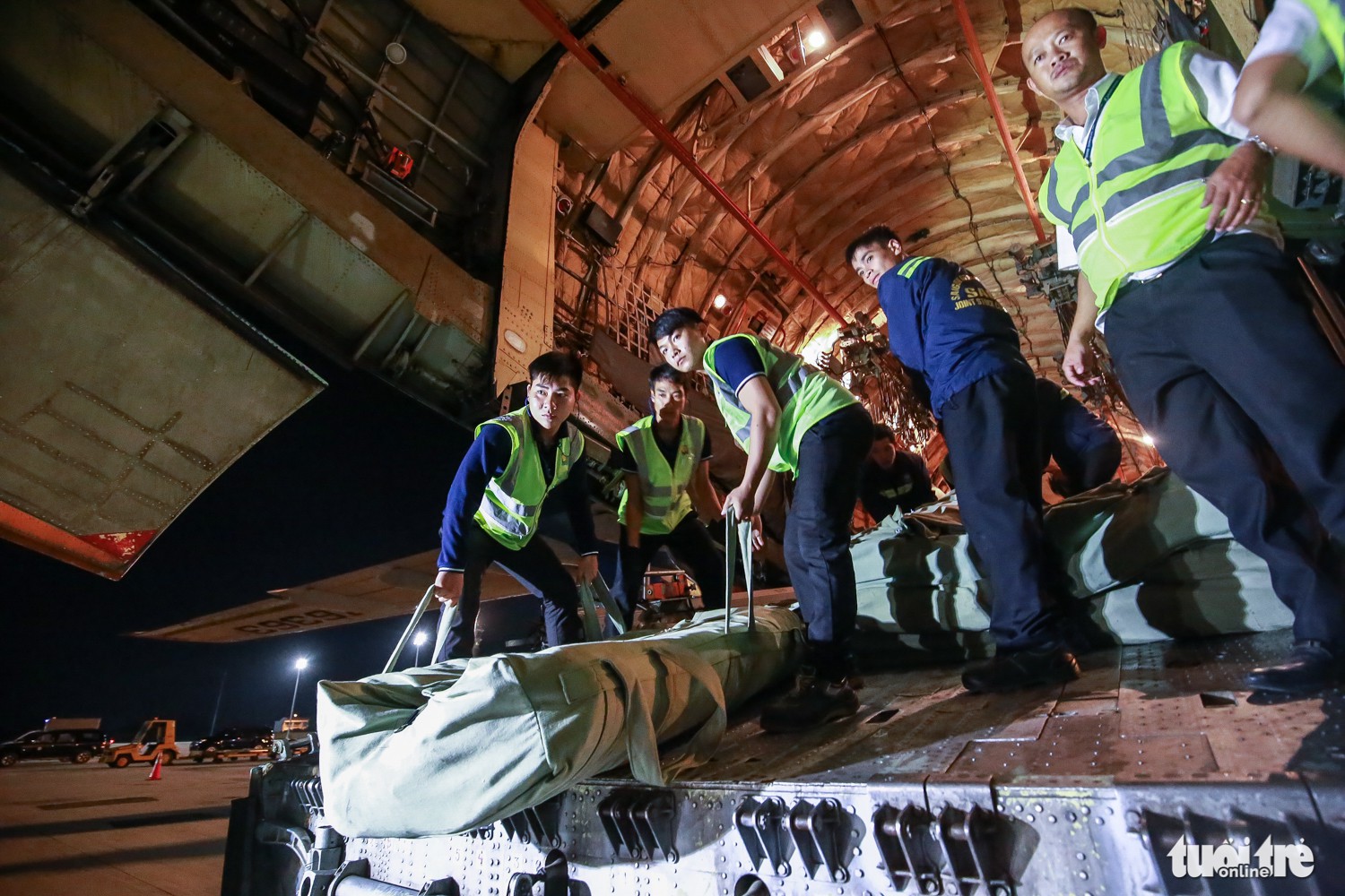 Airport workers help unload goods from the aircraft. Photo: Tuoi Tre
