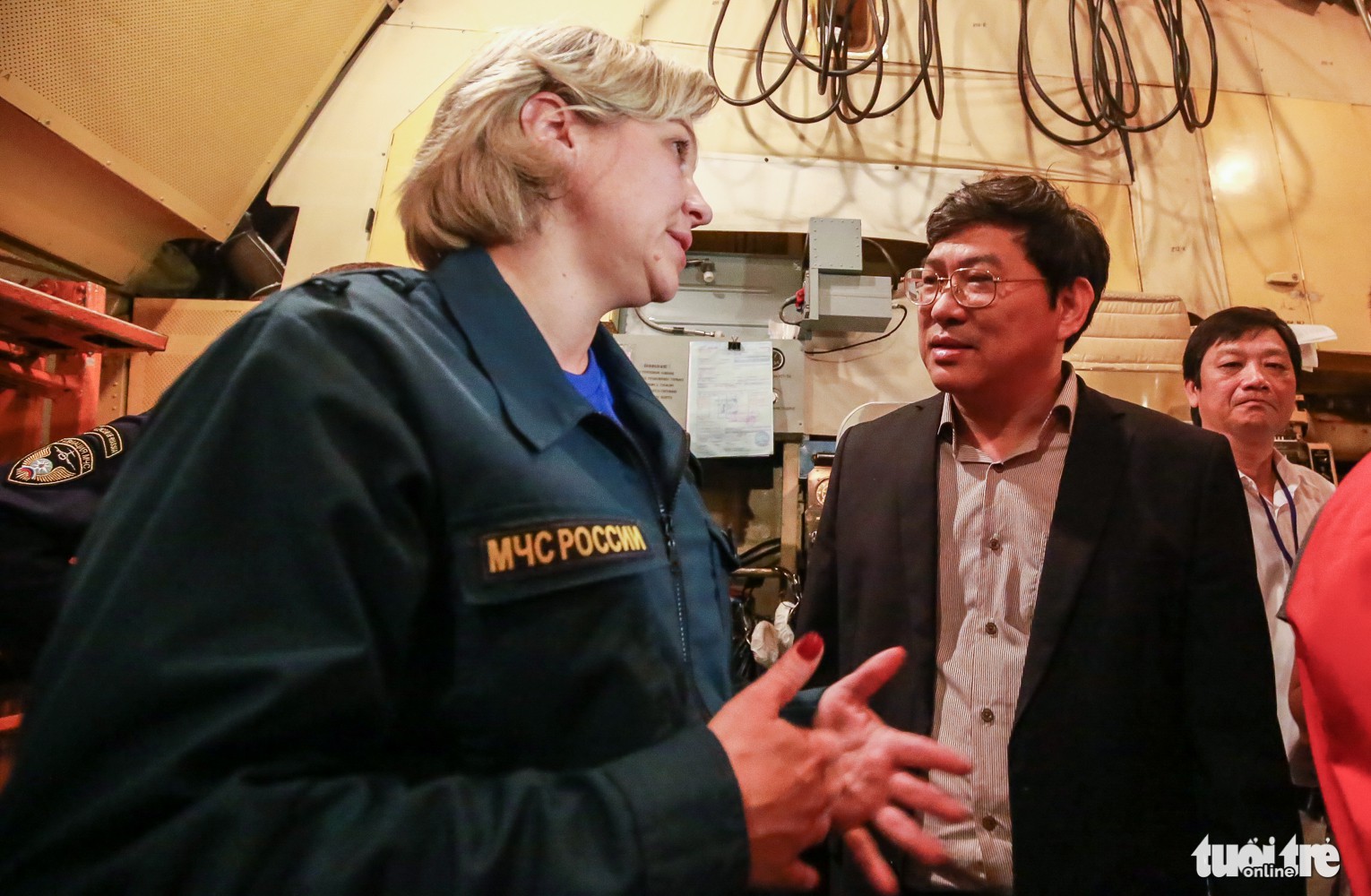 Nguyen Duy Bac (R), deputy chairman of Khanh Hoa Province, speaks with a crew member from the Russian aircraft. Photo: Tuoi Tre