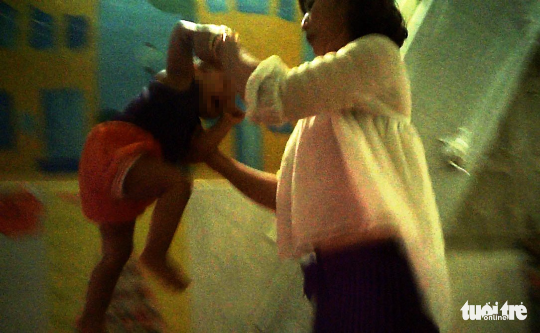 A young boy is violently lifted up at the facility. Photo: Tuoi Tre