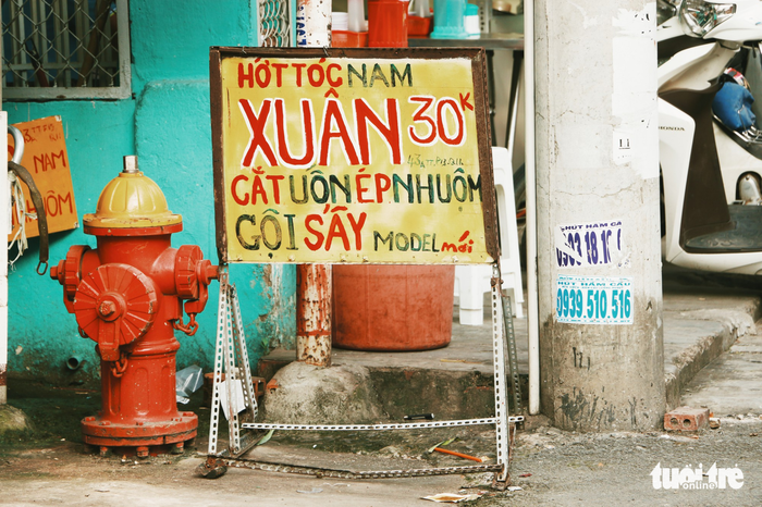 A barber’s sign gracefully self-painted by owner in an alley in District 11. Photo: NGHIA COCO