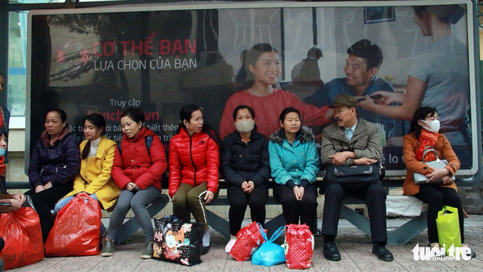 People endure the cold as they wait for a bus.