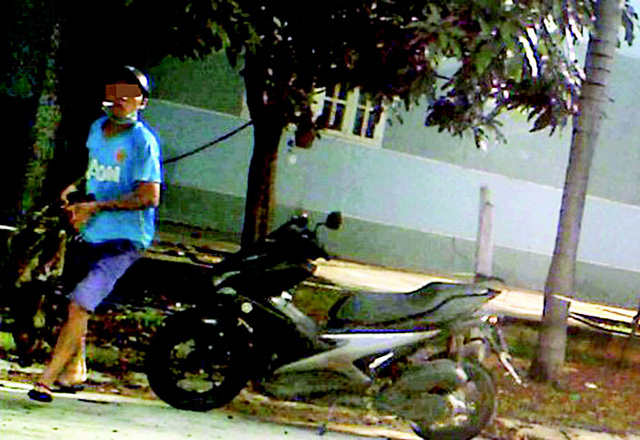 A thief carries a dog that was killed by poison in Binh Duong Province. Photo: Tuoi Tre