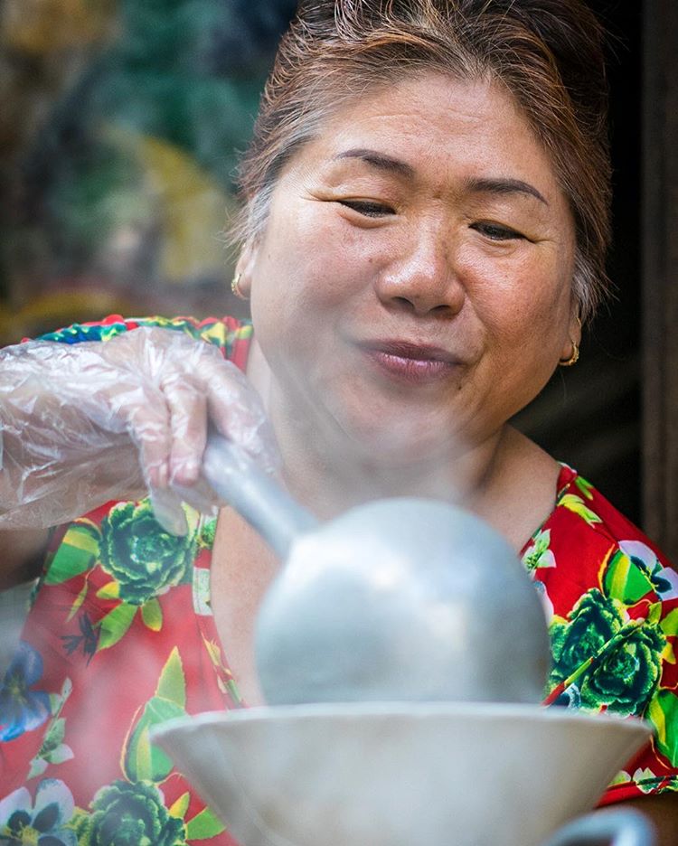 The genuine pleasure and pride that this woman's face exudes in the simple act of serving a bowl of 