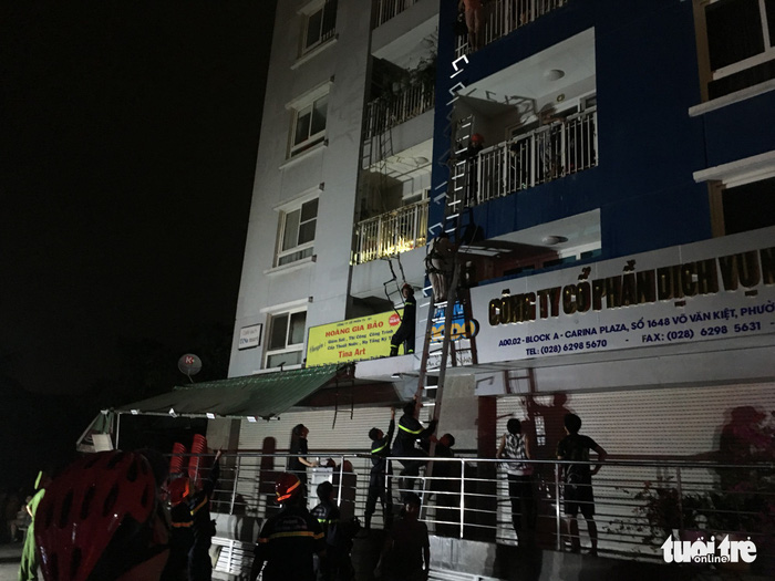 People climb out of the building. Photo: Tuoi Tre