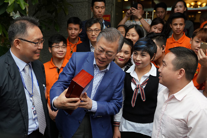 South Korean President Moon Jae-in holds the gift given by the restaurant, a pair of chopsticks. Photo: Tuoi Tre