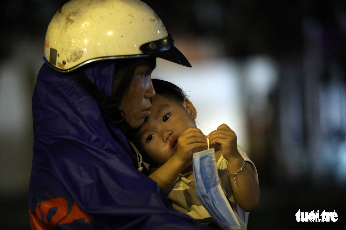 An exhausted woman holds her daughter.
