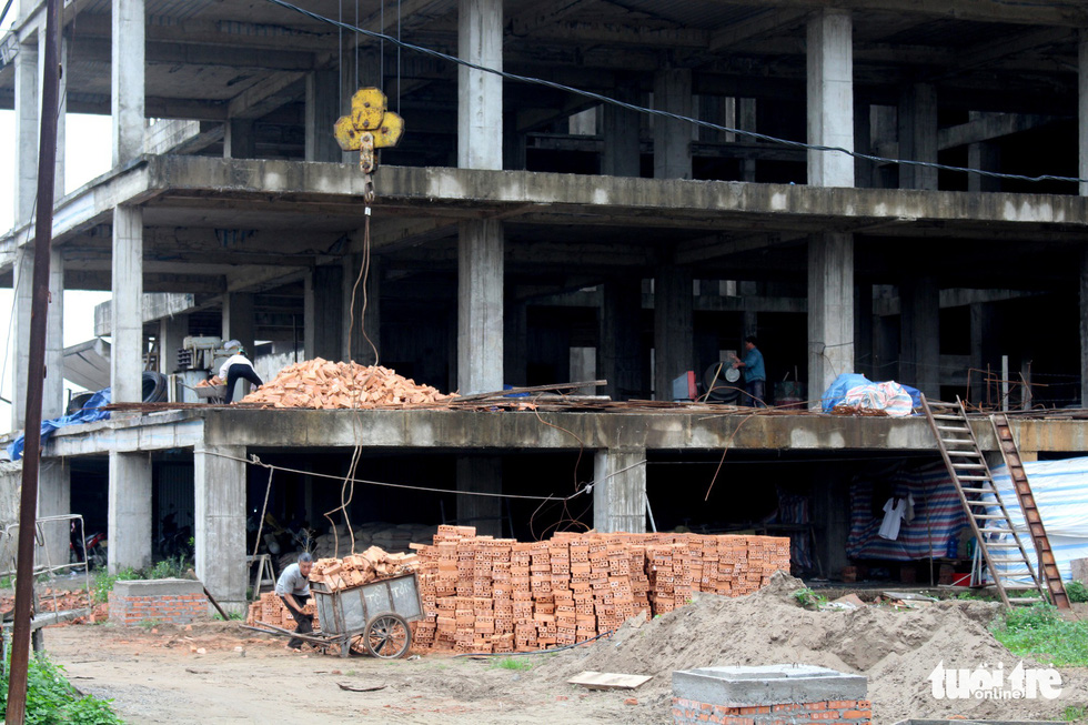 Men work on a floor of the unfinished hospital in Nam Dinh Province, Vietnam. Photo: Tuoi Tre