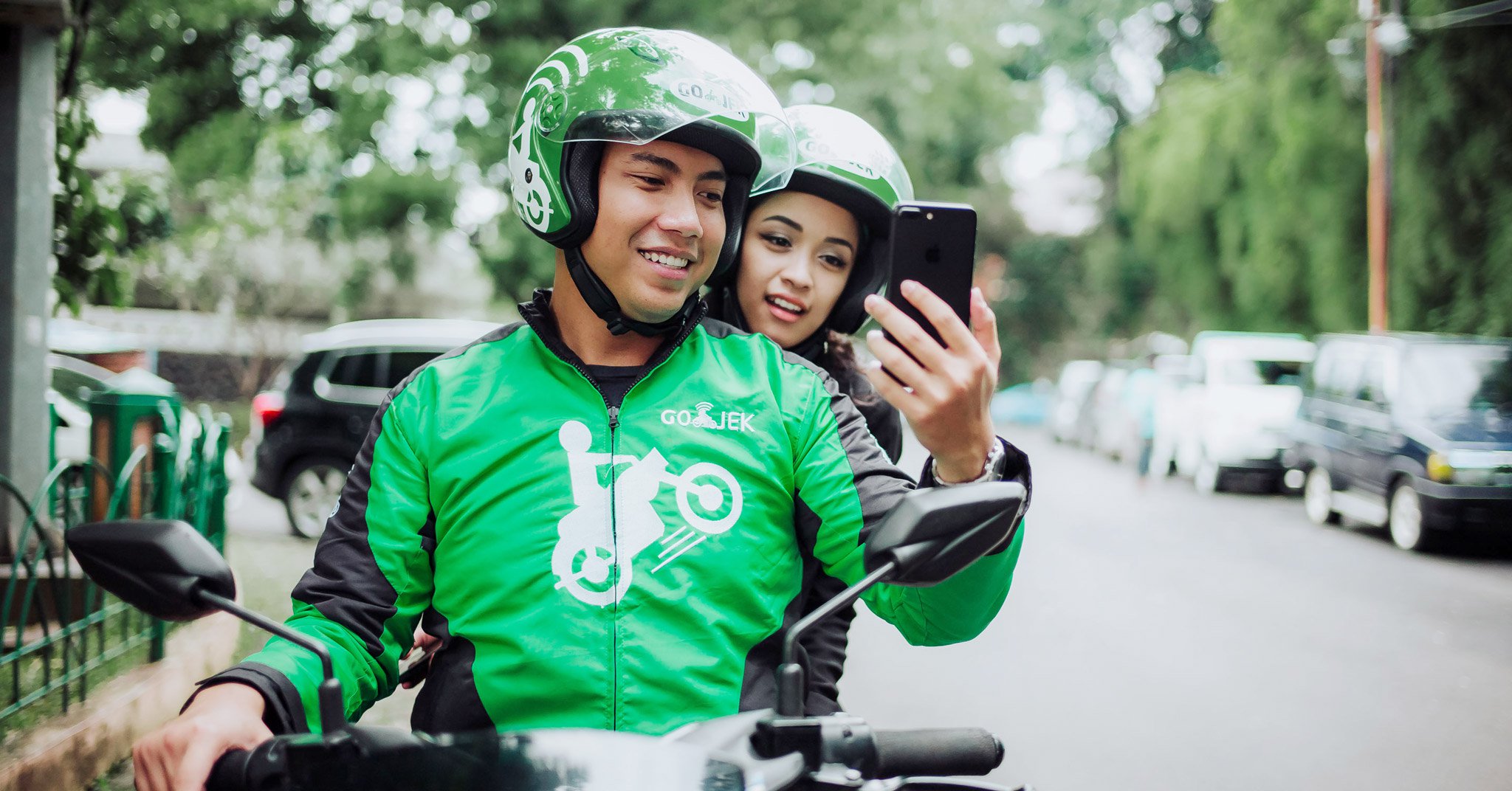 A Go-Jek driver rides a customer through a  street in Jakarta, Indonesia. Photo: Go-Jek