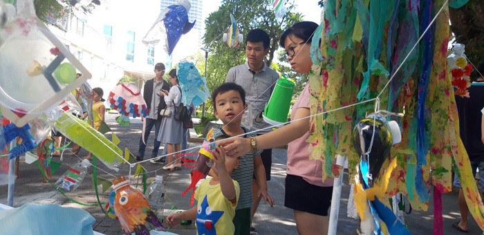 Boys and a woman look plastic fish at the ‘Plastic Monster’ exhibition in Da Nang, Vietnam, June 30 and July 1, 2018. Photo: Tuoi Tre