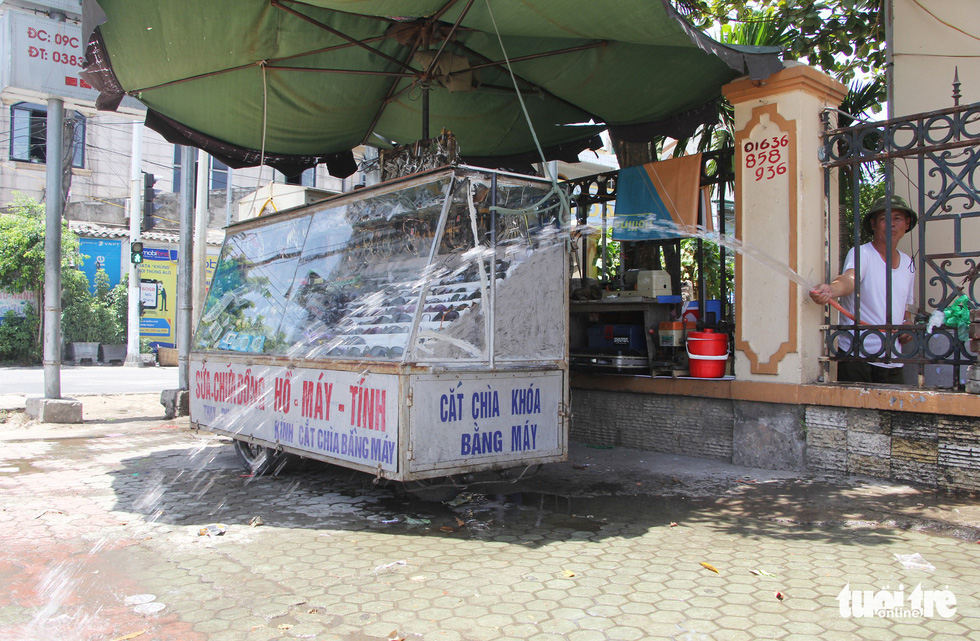 An owner of a key shop sprinkle water around his stall to cool off the atmosphere.
.