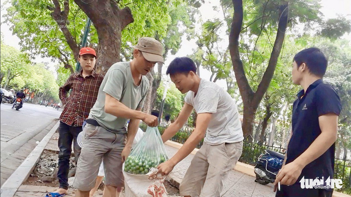 A sau picker sells his fruit on the sidewalk in Hanoi. Photo: Tuoi Tre
