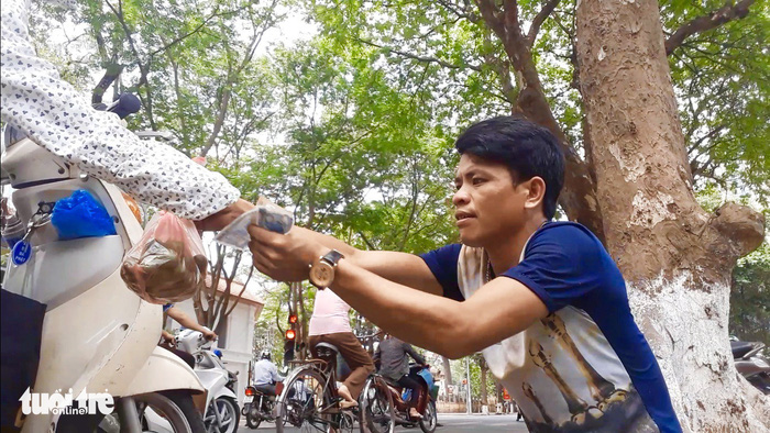 A sau picker sells his fruit on the sidewalk in Hanoi. Photo: Tuoi Tre