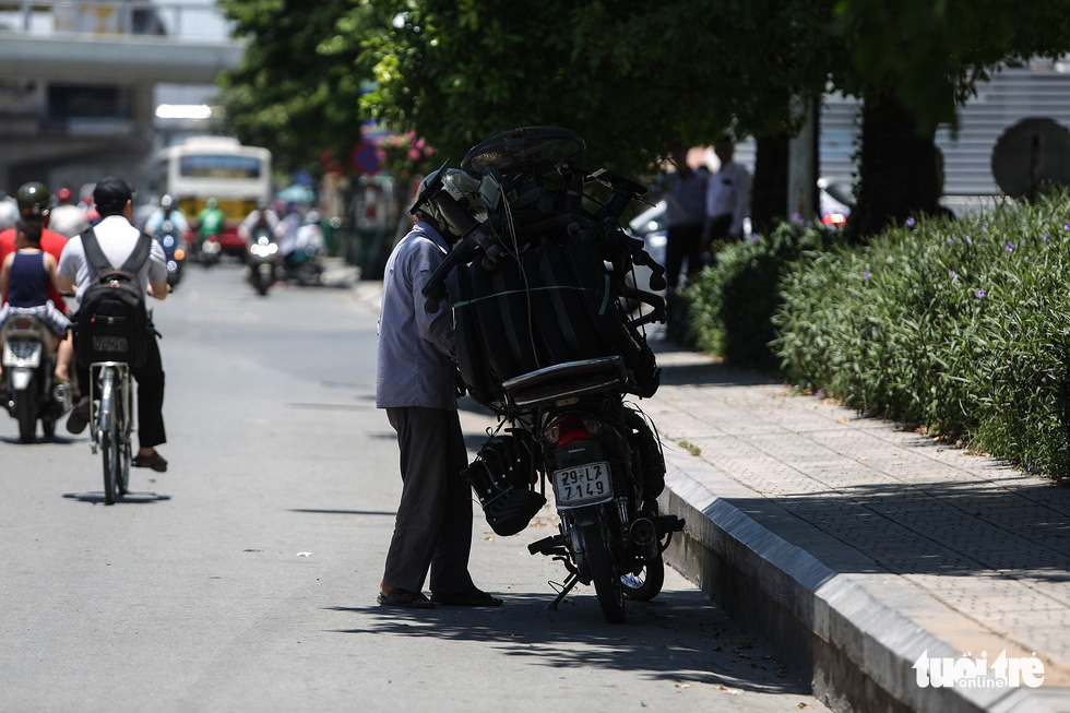 A commuter takes a short break under the shade.