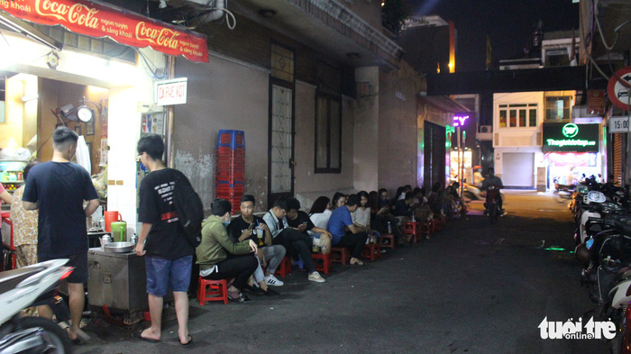 Young visitors sit on plastic chairs to enjoy the coffee at the net-filter café. Photo: Tuoi Tre