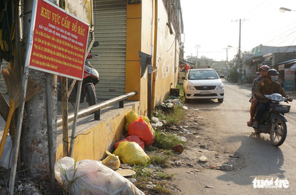 Rubbish is often dumped at night despite a prohibition sign at a neighborhood in Binh Chanh District.