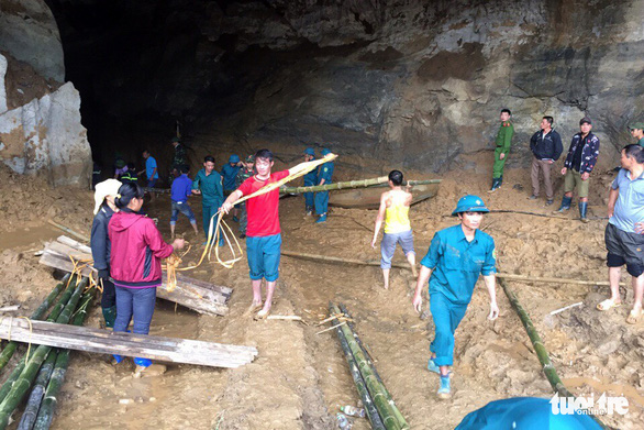 People tie bamboos to be used as a road over the cave’s muddy floor in Hoa Binh Province, northern Vietnam, November 5, 2018. Photo: Tuoi Tre