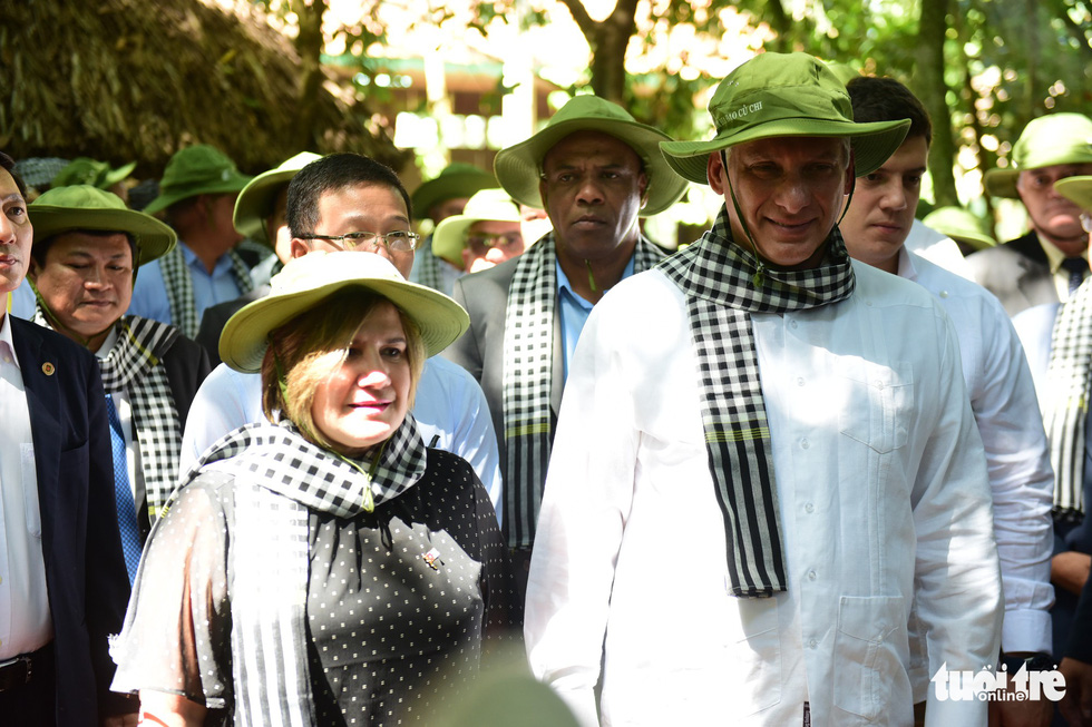 The president and his spouse wear traditional hats and scarves during their visit.