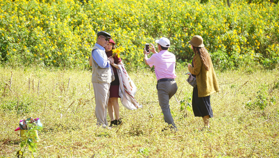 Visitors pose for a photo with the unique blossoms.