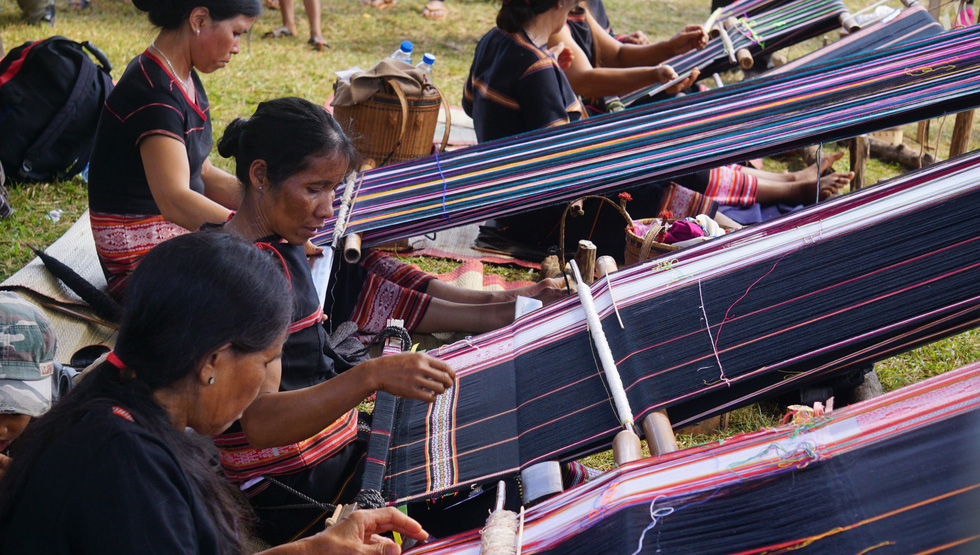 Local villagers weave brocade at the event.