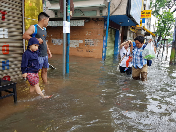 Pedestrian walk in flood water in Ho Chi Minh City on November 26, 2018. Photo: Tuoi Tre