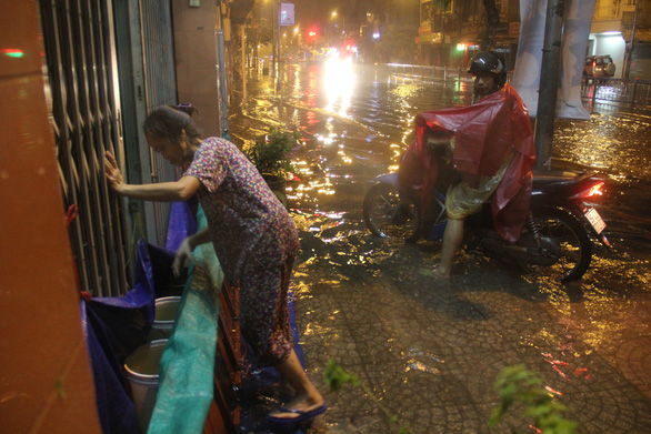 A resident builds a barricade to prevent floodwater from entering her house in Ho Chi Minh City on November 26, 2018. Photo: Tuoi Tre