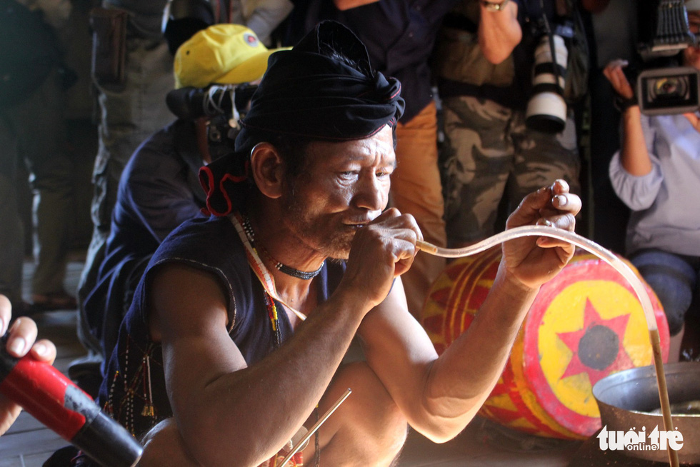 A village elder drinks Vietnamese fermented rice wine after the completion of a ritual before inviting guests. Photo: Tuoi Tre