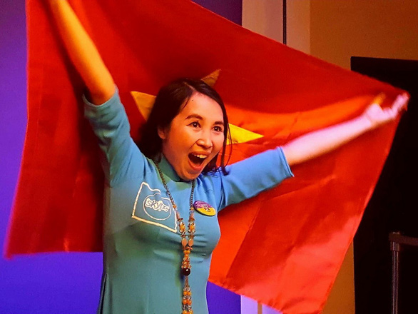  Tran Thi Thuy happily shows off a Vietnamese flag as she is awarded at the Microsoft Education Exchange 2017 conference. Photo: Tuoi Tre