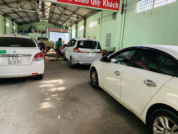 Cars wait for their turn to be repainted at a shop. Photo: Cong Trung / Tuoi Tre